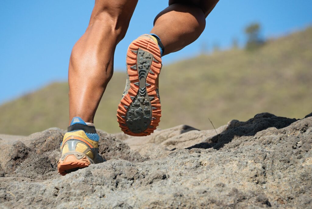 Trailrunning Läufer beim Bergtrail beim Laufen bergauf Belastung für Achillessehne