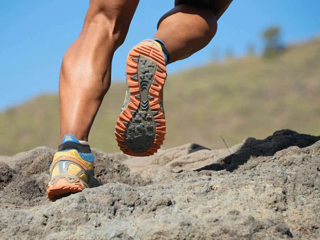 Trailrunning Läufer beim Bergtrail beim Laufen bergauf Belastung für Achillessehne, Gefahr für Achillessehnenentzündung