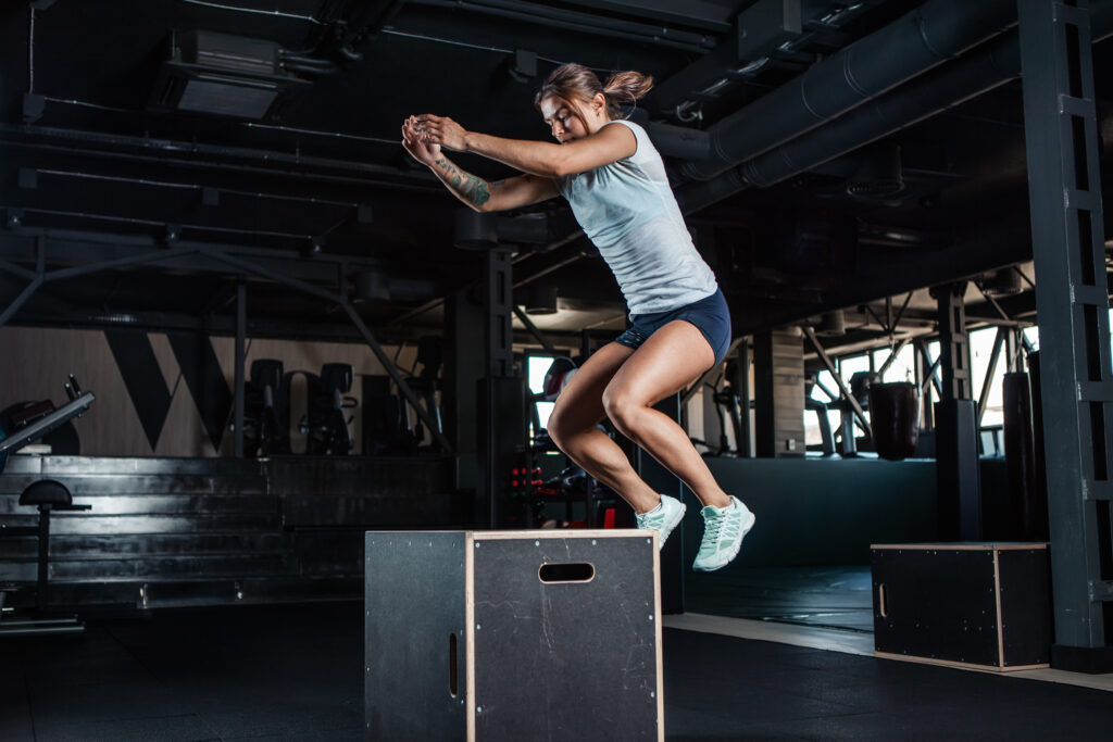 Fitness-Training in CrossFit Gym mit Box Jump Overs