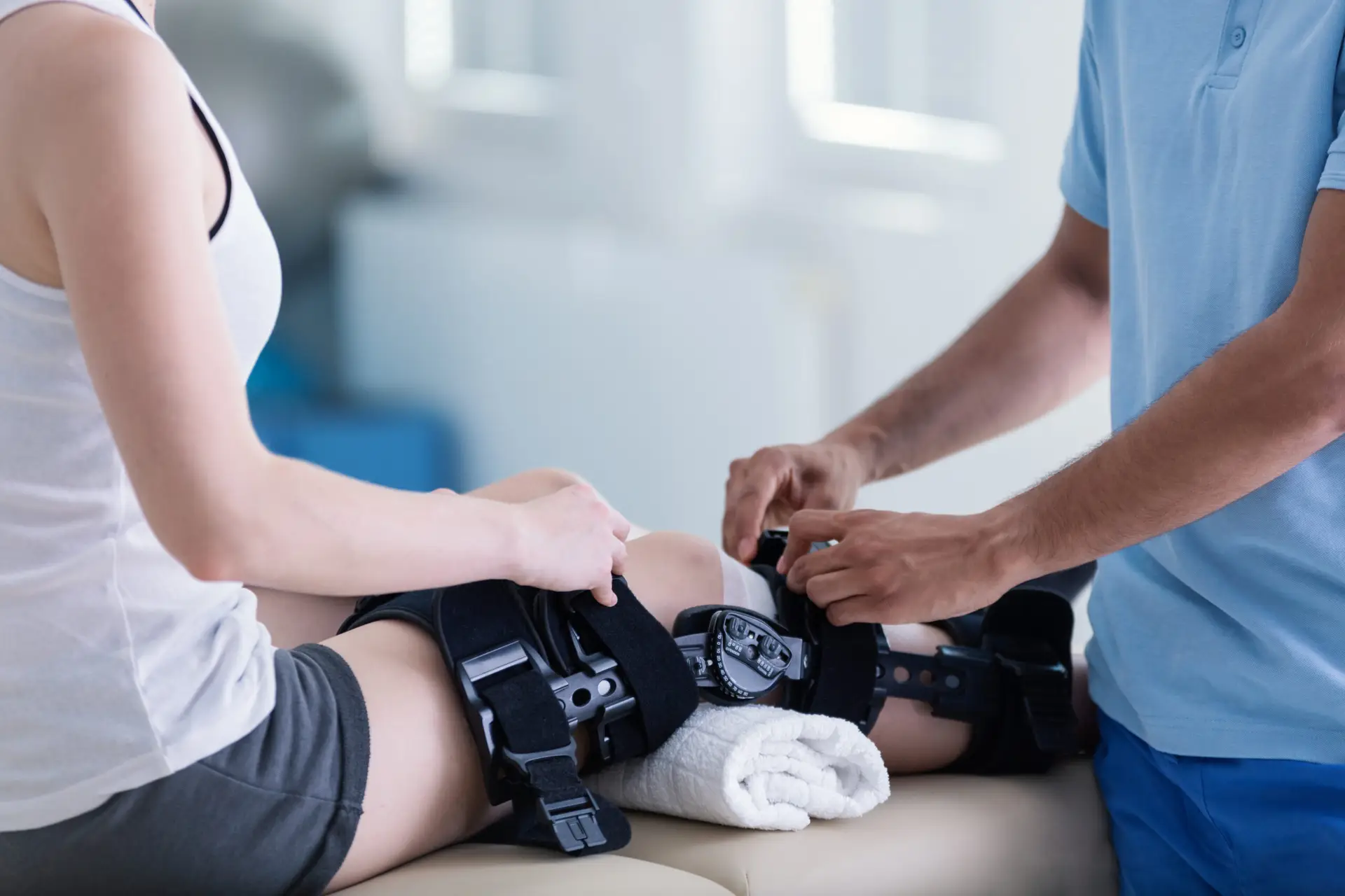 Arzt post-OP bei Untersuchung Knie-Gelenk nach Knie-OP