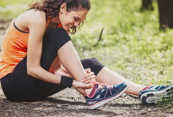 Läuferin beim Training mit Achillessehnenschmerzen