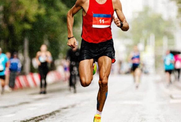 Marathonläufer auf einer Straße mit Belastung für Schienbein, Knie, Muskulatur, Sehnen, Gelenke